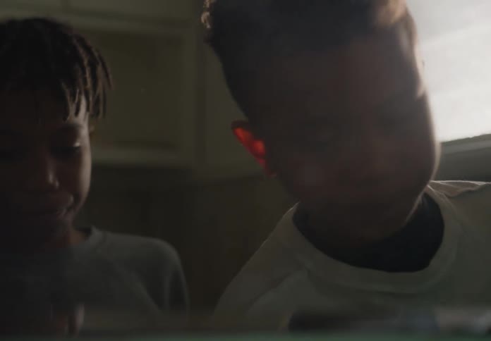 Two boys standing next to each other spitting into a sink and wiping their mouths
