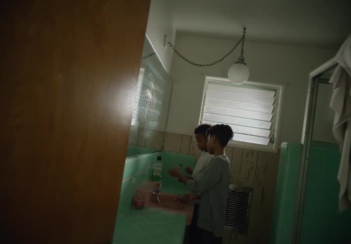 Two tween brothers in bathroom standing at the sink brushing teeth