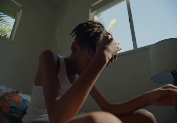 Bored young boy sitting on a room at home next to a window
