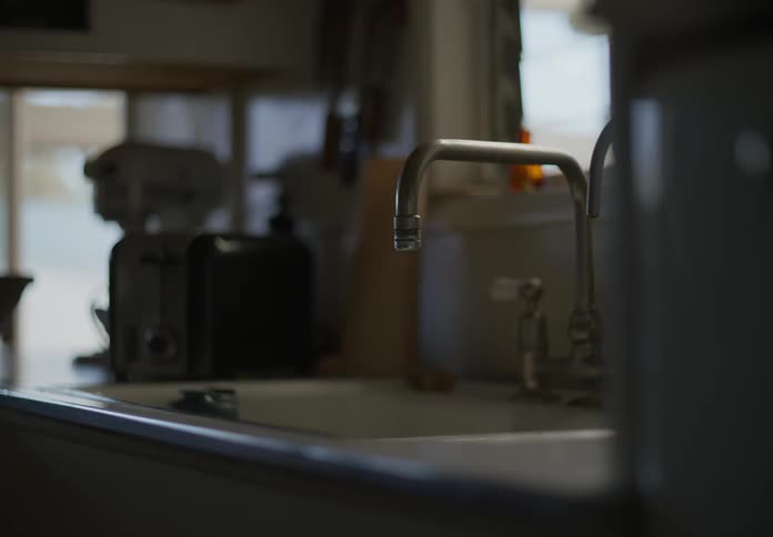 Close up of the dripping faucet on the kitchen sink at home