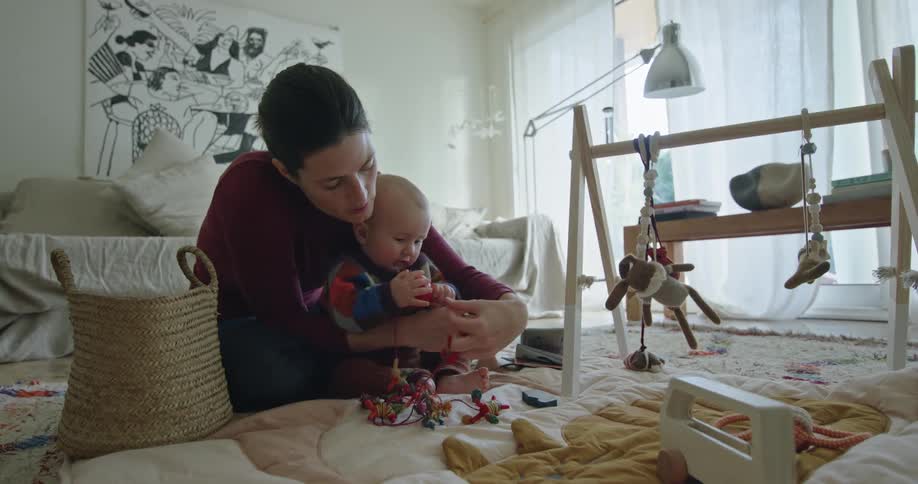 A mother and son play together with toys