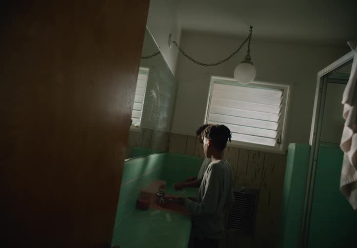 Two tween brothers walk into the bathroom and brush their teeth together while standing at the sink