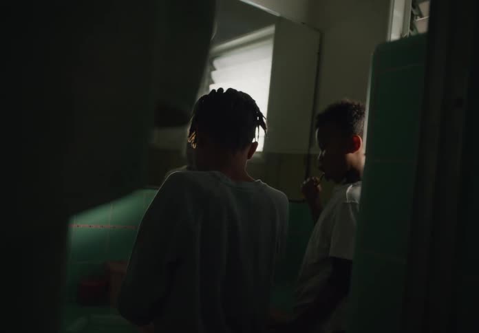 Young brothers brushing their teeth together in the bathroom at home