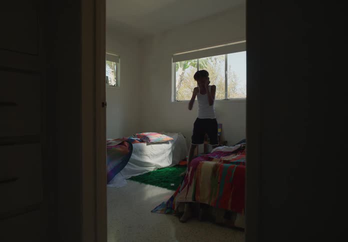 Two tween brothers in bedroom roughhouse playing shadow boxing having fun