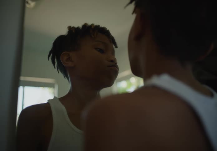 A child is examining his face in the mirror