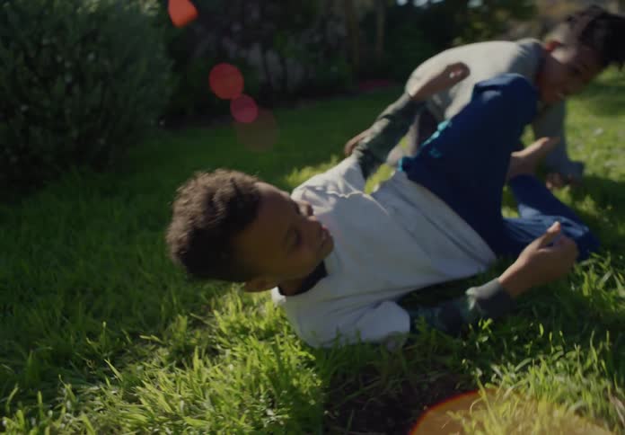 Two tween brothers playwrestling in the yard during the day