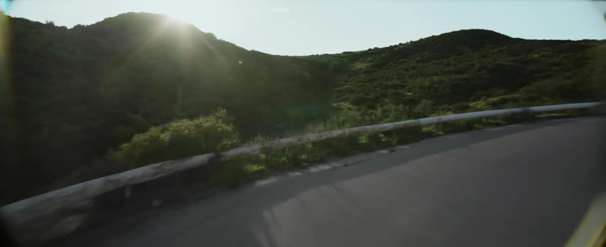 Aerial view of a car driving on a road in the mountains at morning