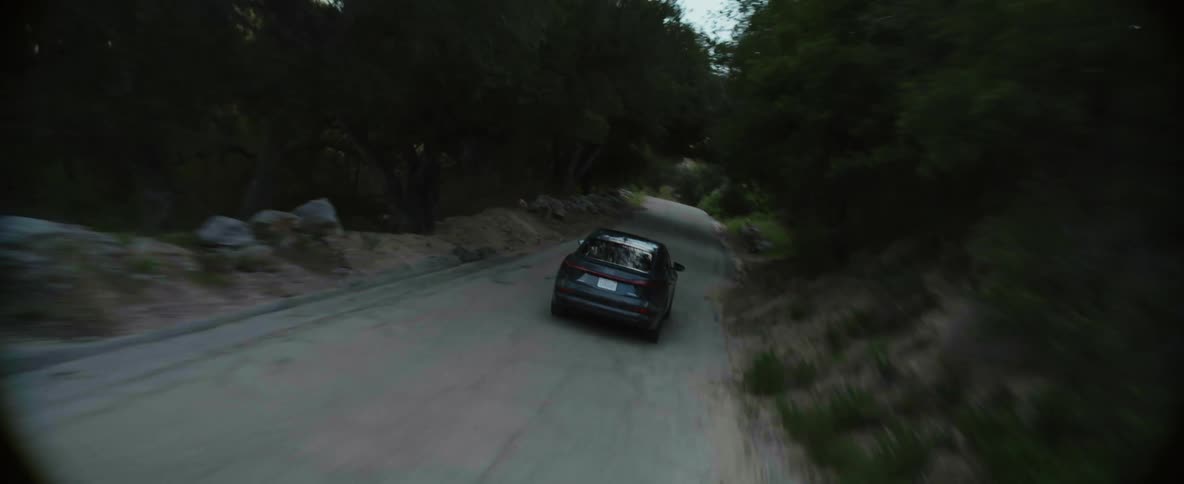 Aerial view of car driving on winding road on country road