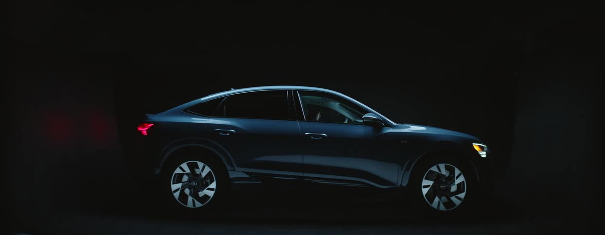Audi etron in showroom environment black background and spotlight with shadows and lights moving over it