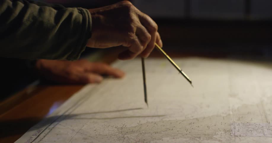 A person uses a compass on a map