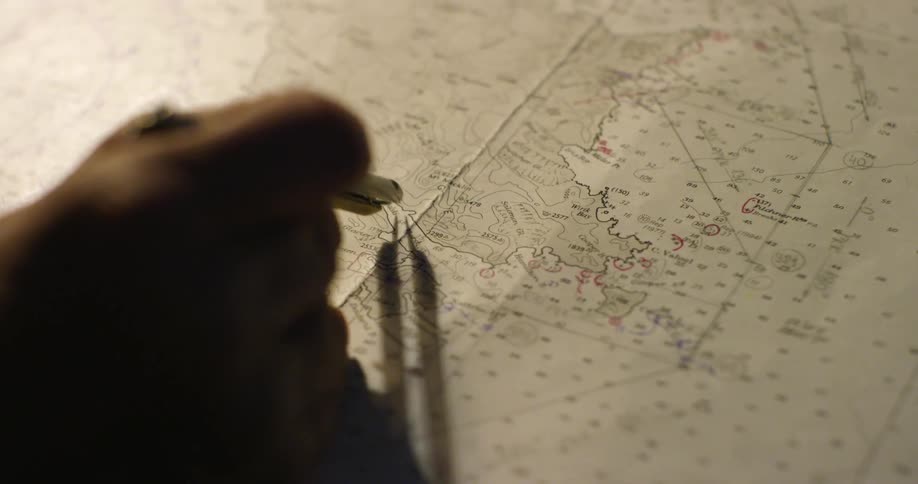 A man traces a compass across a map