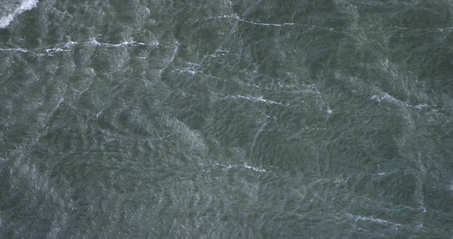 The water below is rough with waves moving