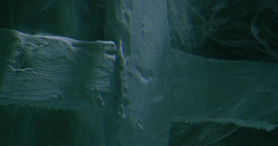 Abstract closeup of white cross symbol underwater with light beams and shadow moving across
