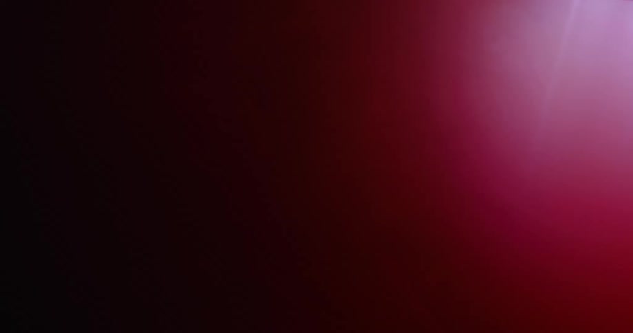 Light pulses brightening portion of crimson surface leaving the rest in shadow