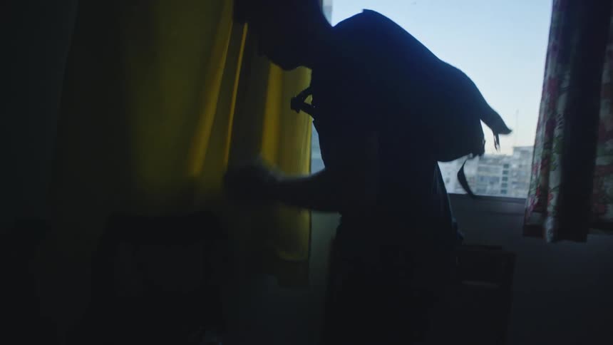 Man gearing up with helmet and backpack on his way out the door to go somewhere on a bicycle