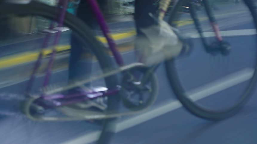 A cyclist pedals their bicycle on a street through town