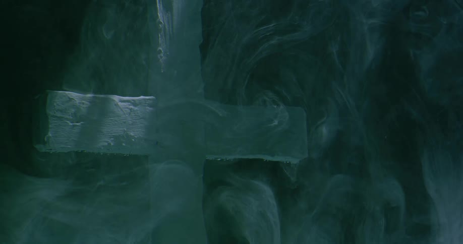 Smoke billows around a wooden cross