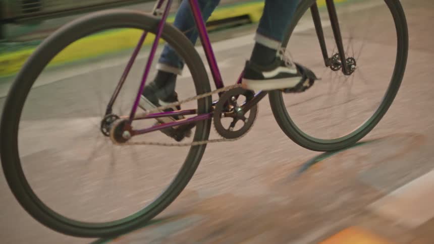 Person pedaling a bicycle in the bike lane at night