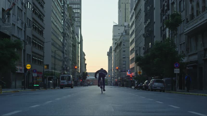 A man rides down the middle of a one way city street