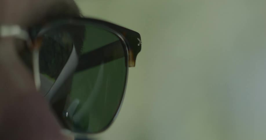 Ecu on a drivers sunglasses left eye while driving during the day