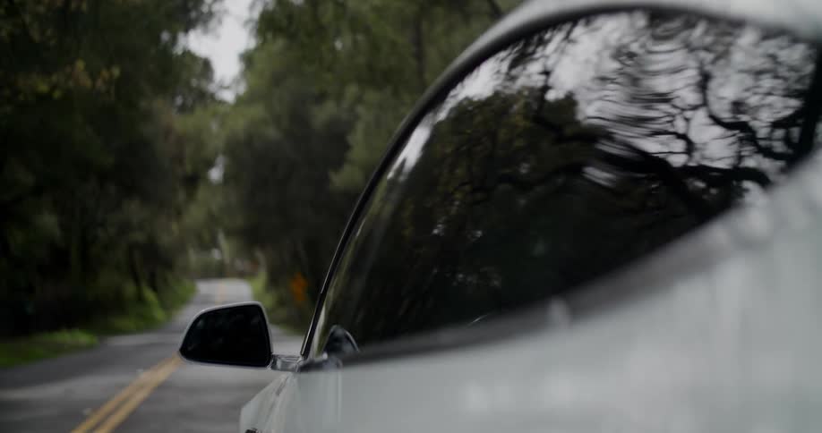 A car is driving through a wooded area