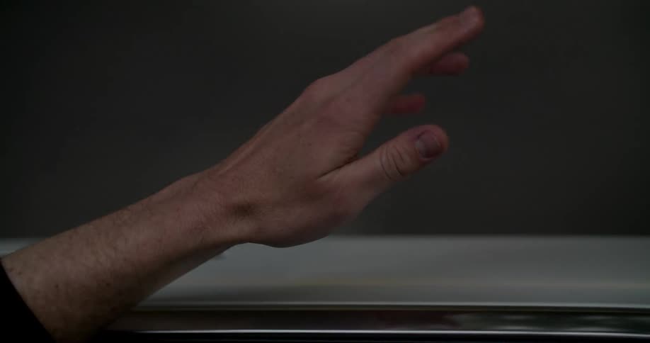 Male drivers hand slightly out the drivers side window feeling the wind