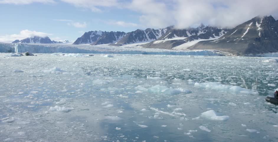 An ice covered body of water with a raft full of people floating nearby