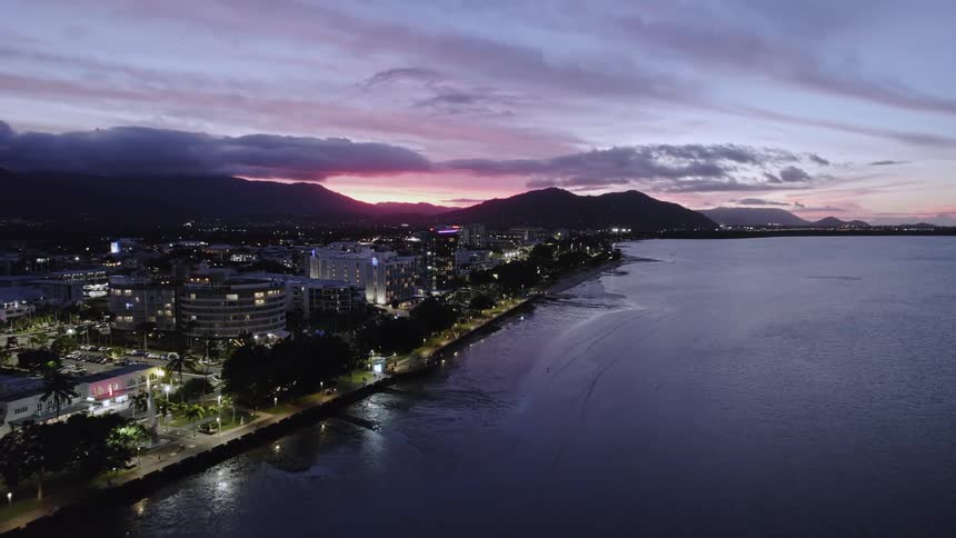 A bustling city along the coast is lit up at night