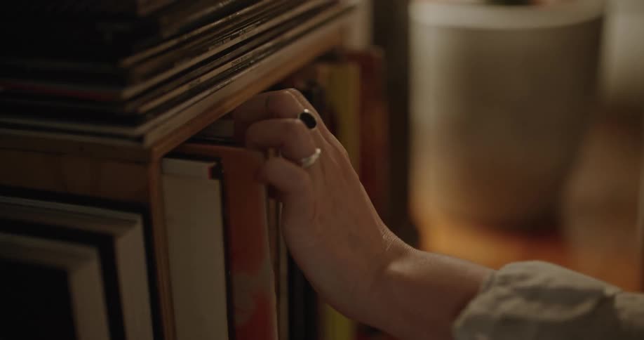 A woman picks through vinyl records in a cabinet