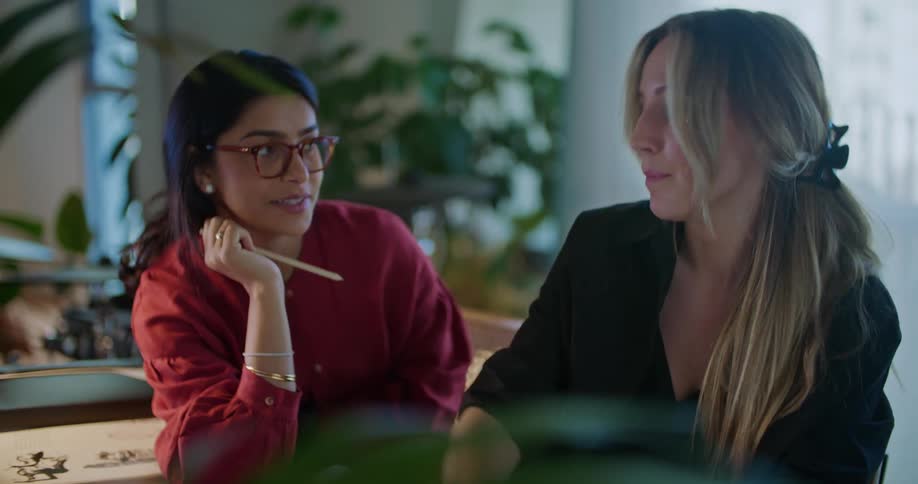 Two female coworkers working on a design on a tablet in the office