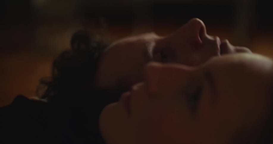 A close up of a man and womans faces laying opposite and looking upward