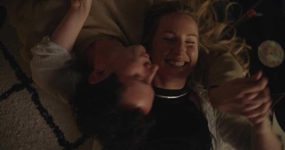 Man and woman are laying on the ground together