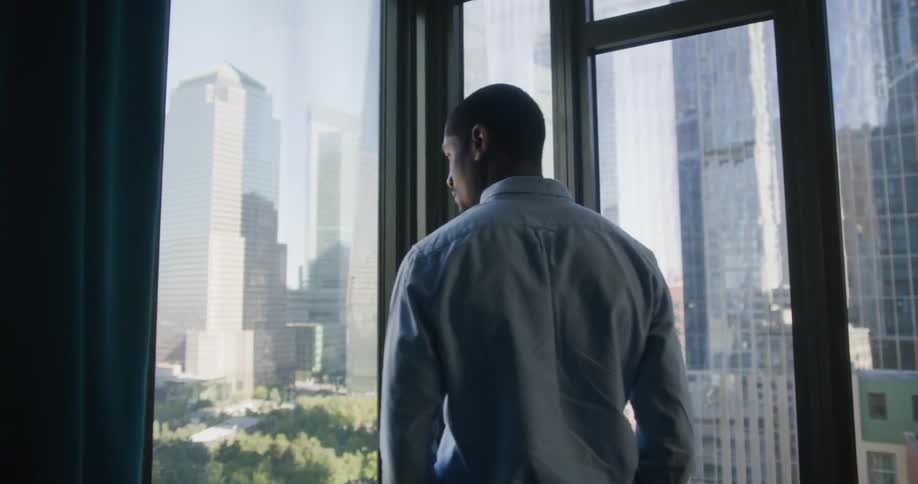A man is walking around a building in a city