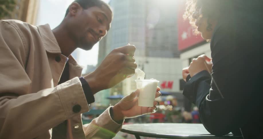Young couple sharing an ice cream in the city at daytime