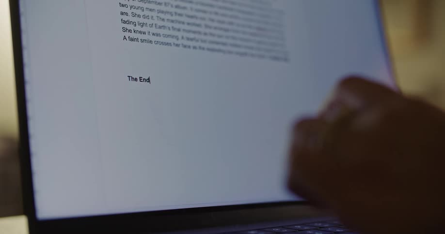 A close up of a laptop screen as a person types on the keyboard and the words come across the screen