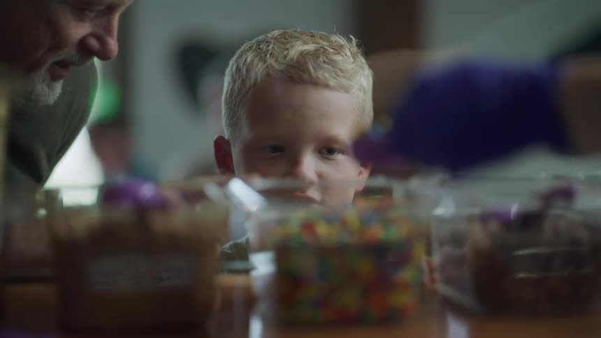 Close up of the face of a happy young boy waiting for candy at the shop