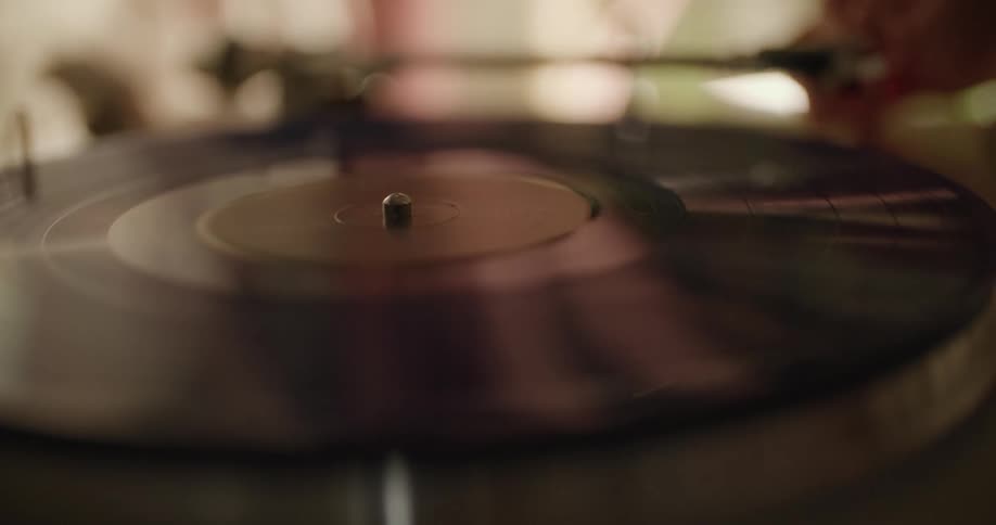 A person puts an album on the turntable