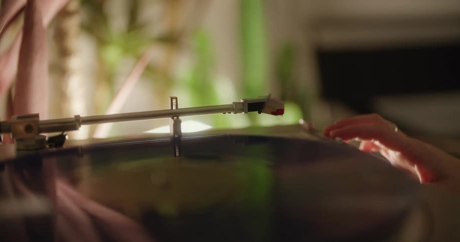 A person puts a record on the player
