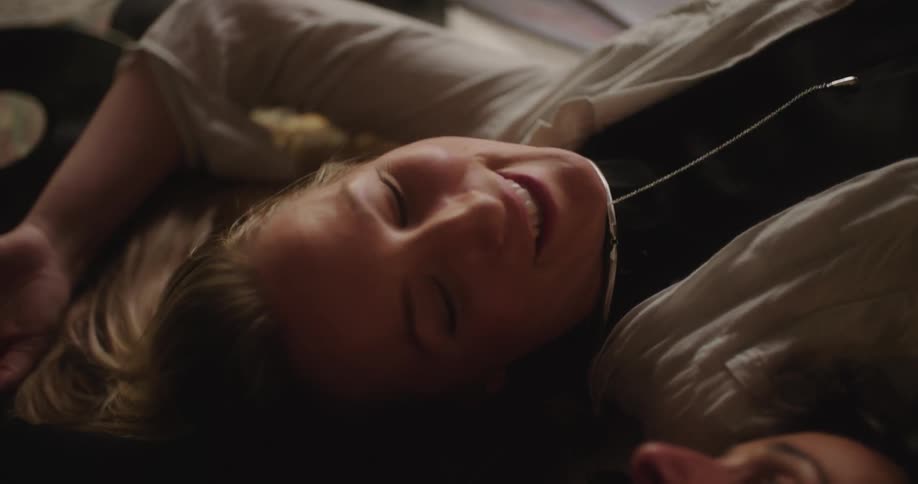Two women laying on the floor laughing and smiling as they talk
