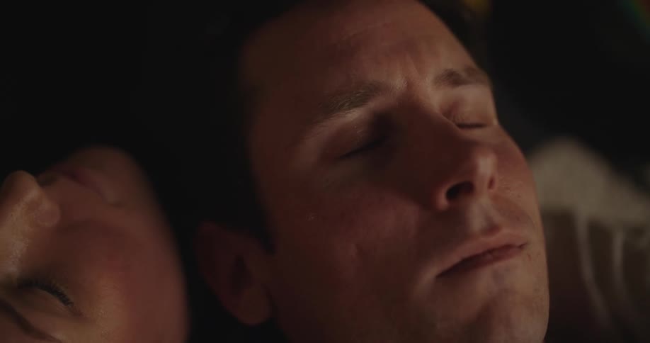 Close up of the face of a sad man holding tears reclined on his lovers chest