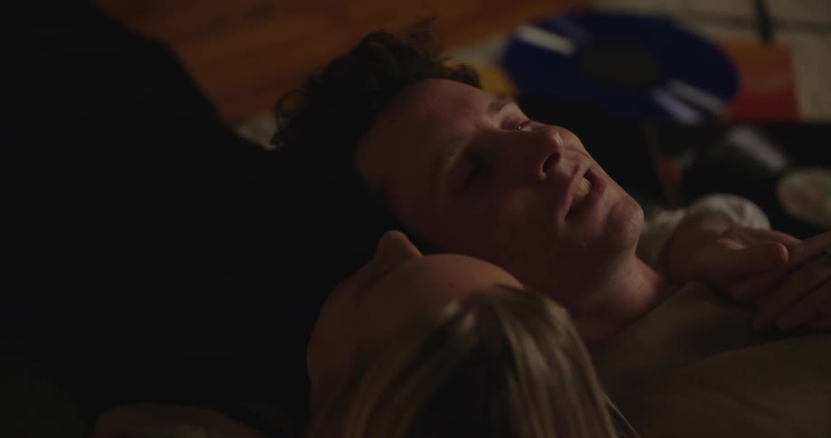 Young couple resting in bed with their heads together having a conversation
