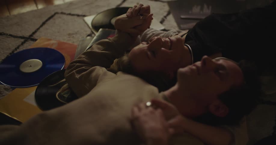 A man and woman laying on the floor holding each other talking smiling and laughing