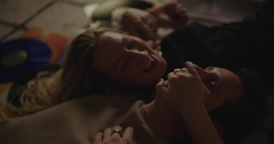 A man and woman lay on the floor talking