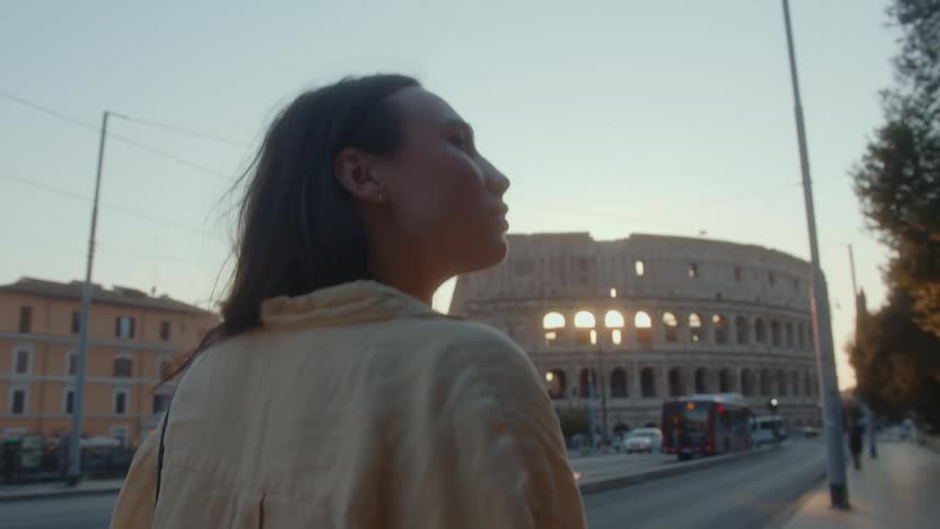 A woman is walking past the coliseum
