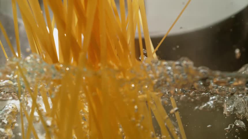 Pasta being dropped into a pot of boiling water