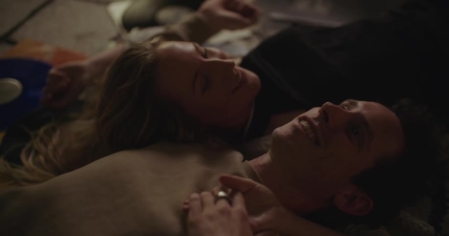 A man and woman talk on the floor