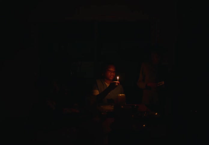 Family light candles in the dining room at home during a blackout at night