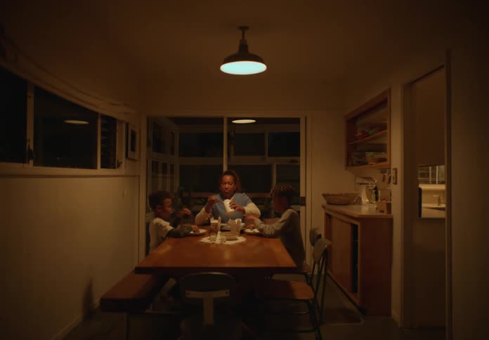 Mother sitting at the dining table at home with their sons pray before eating at night