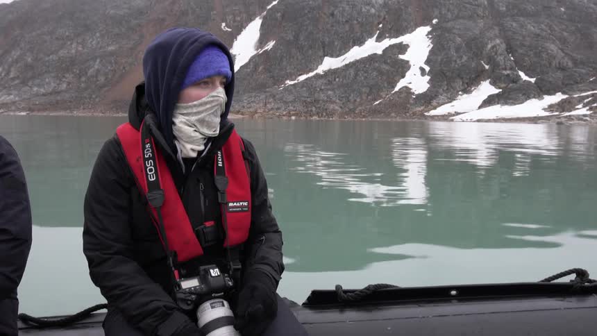A person wearing a face mask is riding in a boat