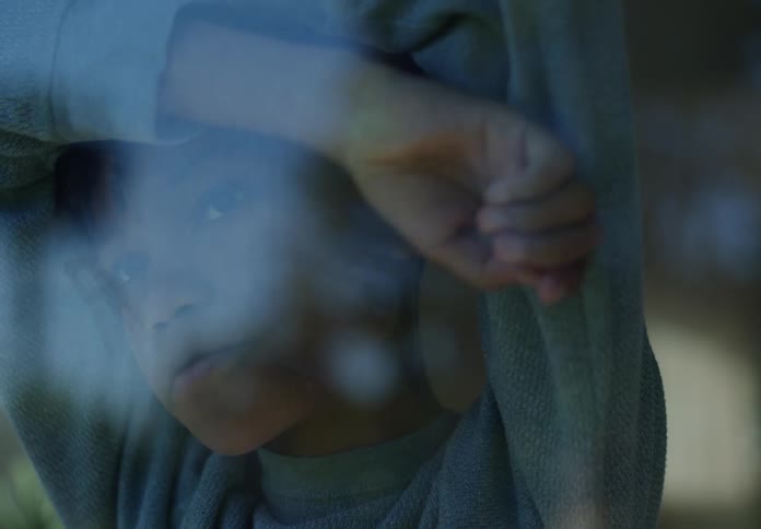A portrait of a person leaning up against a window